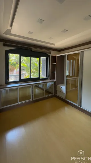 Sala de estar com grandes janelas e piso de madeira clara.