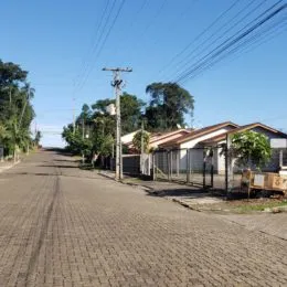 Vista externa de uma rua pavimentada com estruturas residenciais ao fundo em Lajeado.