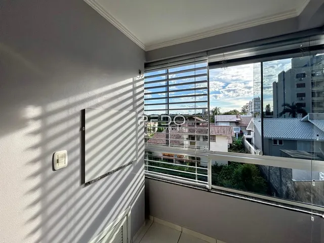 Parede interna com janela de grande porte e vista da paisagem.