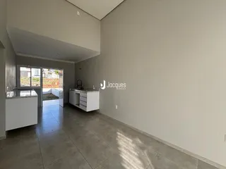 Interior de uma sala com piso de cerâmica e portas de vidro que dão acesso ao exterior.