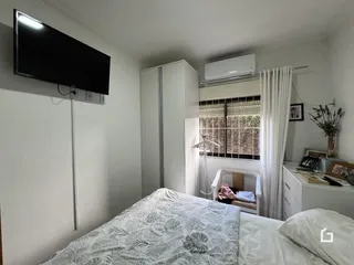 Quarto com cama e guarda-roupa em ambiente interno.