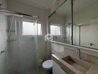 Banheiro com box de vidro e janela.