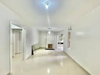 Corredor interno de uma residência branca com piso claro.