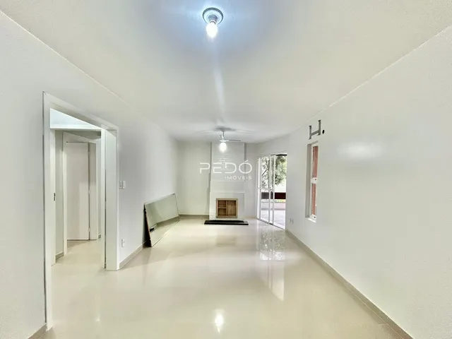 Corredor interno de uma residência branca com piso claro.