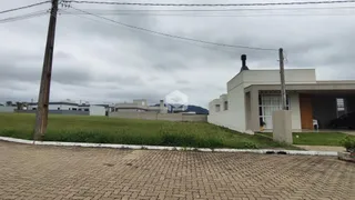 Vista externa de uma residência com jardim e área pavimentada.