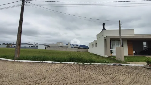 Vista externa de uma residência com jardim e área pavimentada.