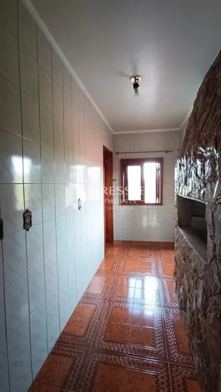 Hall de entrada com piso de cerâmica terracota e paredes brancas.