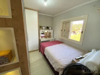 Quarto com cama de casal e janela de madeira.