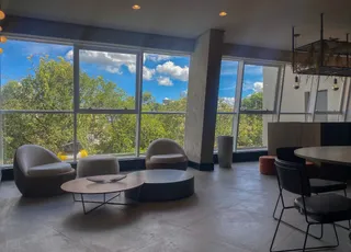 Sala de estar com grandes janelas que dão vista para a natureza.