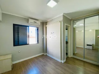 Ambiente interno com piso de madeira e parede cinza claro.