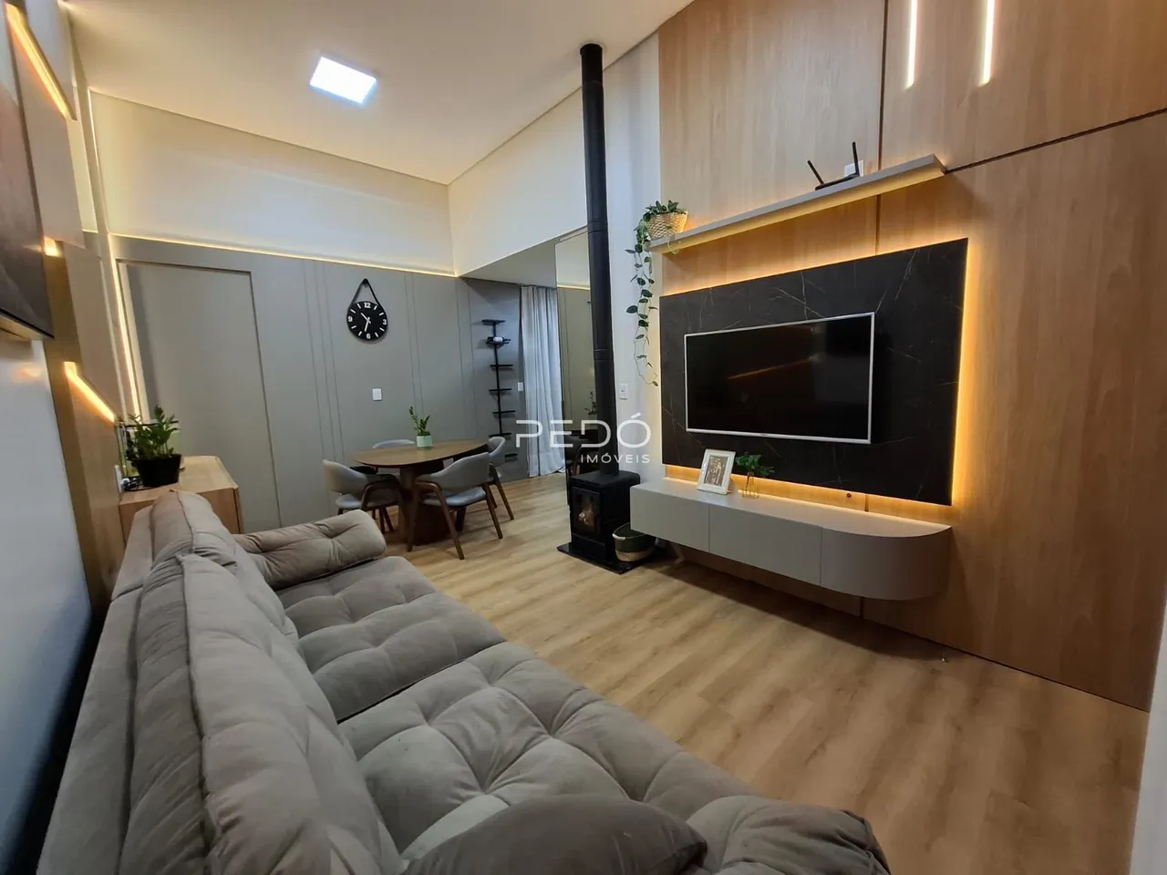 Sala de estar moderna com piso de madeira clara e decoração contemporânea.