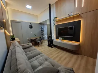 Sala de estar moderna com piso de madeira clara e decoração contemporânea.