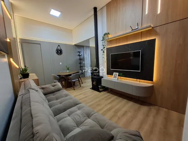 Sala de estar moderna com piso de madeira clara e decoração contemporânea.