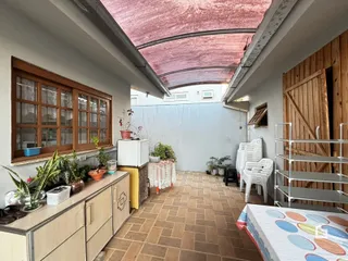 Vista de um corredor com piso de cerâmica e teto abobadado em uma residência.