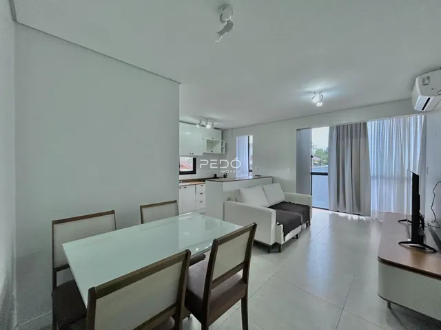 Sala de jantar e estar com cozinha integrada em um apartamento.