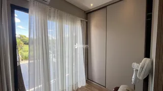 Vista de uma janela com cortinas brancas em um ambiente interno.