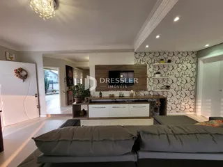 Sala de estar moderna com sofá e painel de TV em um apartamento.