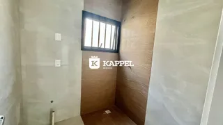 Hall de corredor com janela e painel de madeira.