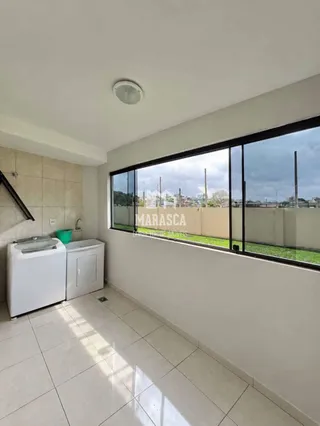 Vista interna de uma sala com piso de cerâmica e grande janela.