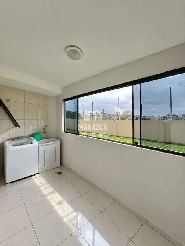 Vista interna de uma sala com piso de cerâmica e grande janela.