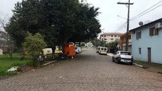 Vista da rua em Lajeado, Brasil, com casas e vegetação ao longo da via.