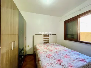Quarto com cama e armário de madeira em um imóvel no Brasil.
