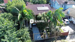 Fachada de uma residência em Lajeado, Brasil, com vegetação exuberante ao redor.
