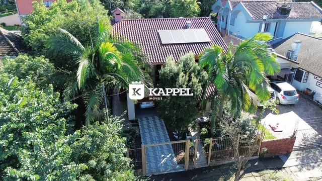 Fachada de uma residência em Lajeado, Brasil, com vegetação exuberante ao redor.