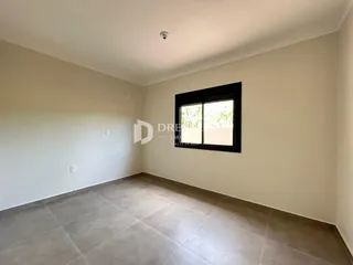 Ambiente interno de uma sala com piso de cerâmica e grande janela.