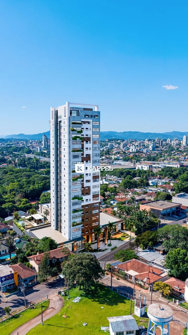Vista aérea de um edifício residencial moderno em Lajeado, Brasil, com áreas verdes ao redor.