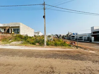 Vista externa de uma propriedade com vegetação e estrada de terra.