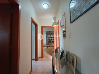 Hall de entrada com portas de madeira e parede branca em um imóvel.