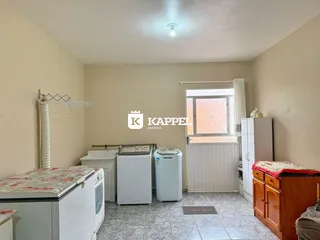 Foto de um cômodo interno com máquina de lavar e secar e piso de cerâmica.