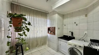 Foto de um banheiro com piso de cerâmica e máquina de lavar roupa.
