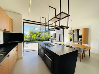 Vista de uma cozinha moderna com portas de vidro abrindo para um pátio.
