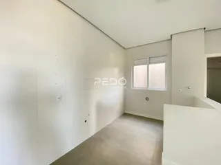 Ambiente interno de uma sala com paredes brancas e piso claro.