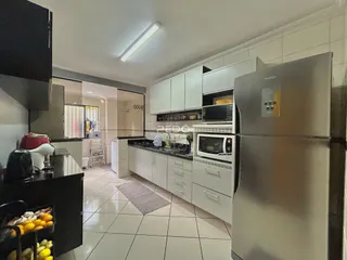 Uma cozinha moderna com armários brancos e eletrodomésticos de aço inoxidável.