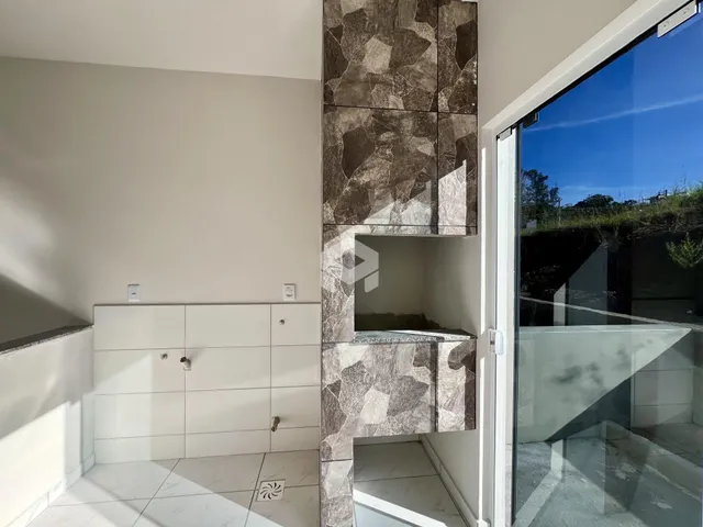 Interior de um ambiente com revestimento de pedra e piso claro.