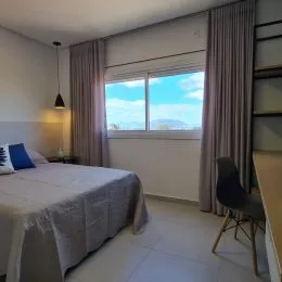 Quarto com cama e janela.