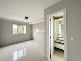 Sala de estar com piso de cerâmica e paredes brancas em um imóvel no Brasil.