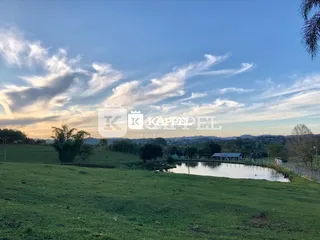 Paisagem de campo com água e céu nublado.