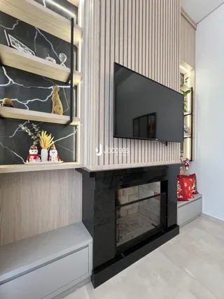 Interior de uma sala de estar com estantes e lareira moderna.
