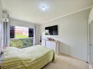 Quarto com cama e janela de vista para a vegetação.