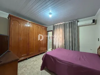 Quarto com armários de madeira e cama em um ambiente interno.