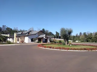 Vista externa de uma propriedade com paisagismo e área pavimentada.