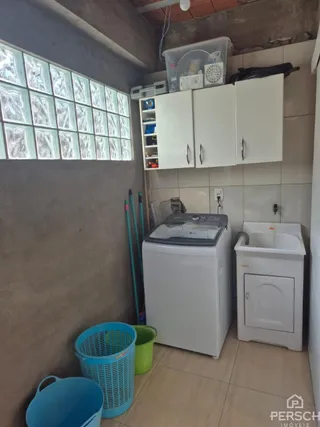 Foto de um cômodo interno com armários brancos e uma máquina de lavar.