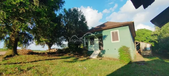 Fachada de uma casa verde em Lajeado, Brasil, com gramado em primeiro plano.