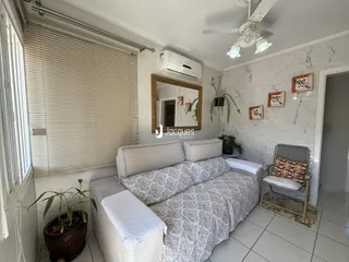 Quarto com paredes brancas e sofá de tecido estampado.
