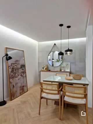 Sala de jantar com mesa de madeira e iluminação moderna.