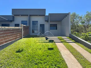 Exterior da casa moderna em Lajeado, com jardim e muro.